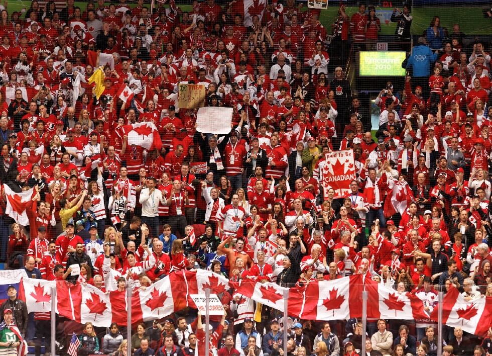 Team Canada fans singing the "Oh Canada" at hockey game.